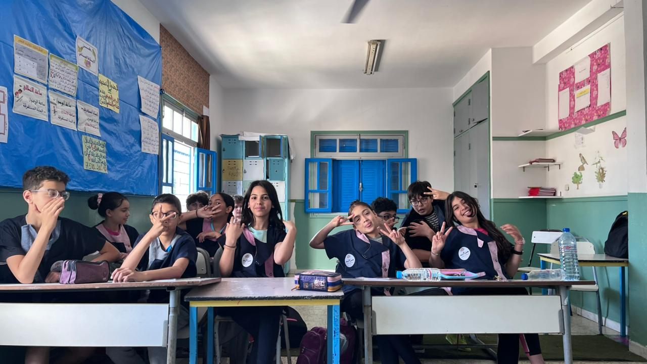 Des élèves en classe, la main levée